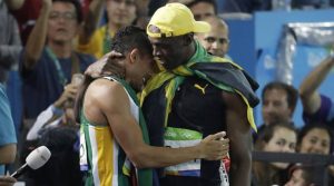 Jamaica's Usain Bolt, right, winner of the men's 100-meter final embraces South Africa's Wayde Van Niekerk, winner of the men's 400-meter final during the athletics competitions of the 2016 Summer Olympics at the Olympic stadium in Rio de Janeiro, Brazil, Sunday, Aug. 14, 2016. (AP Photo/Julio Cortez)